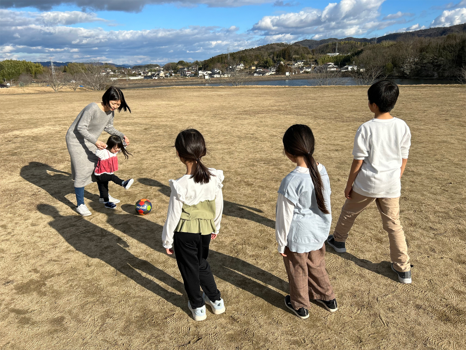 家族でボールを蹴って遊んでいる様子